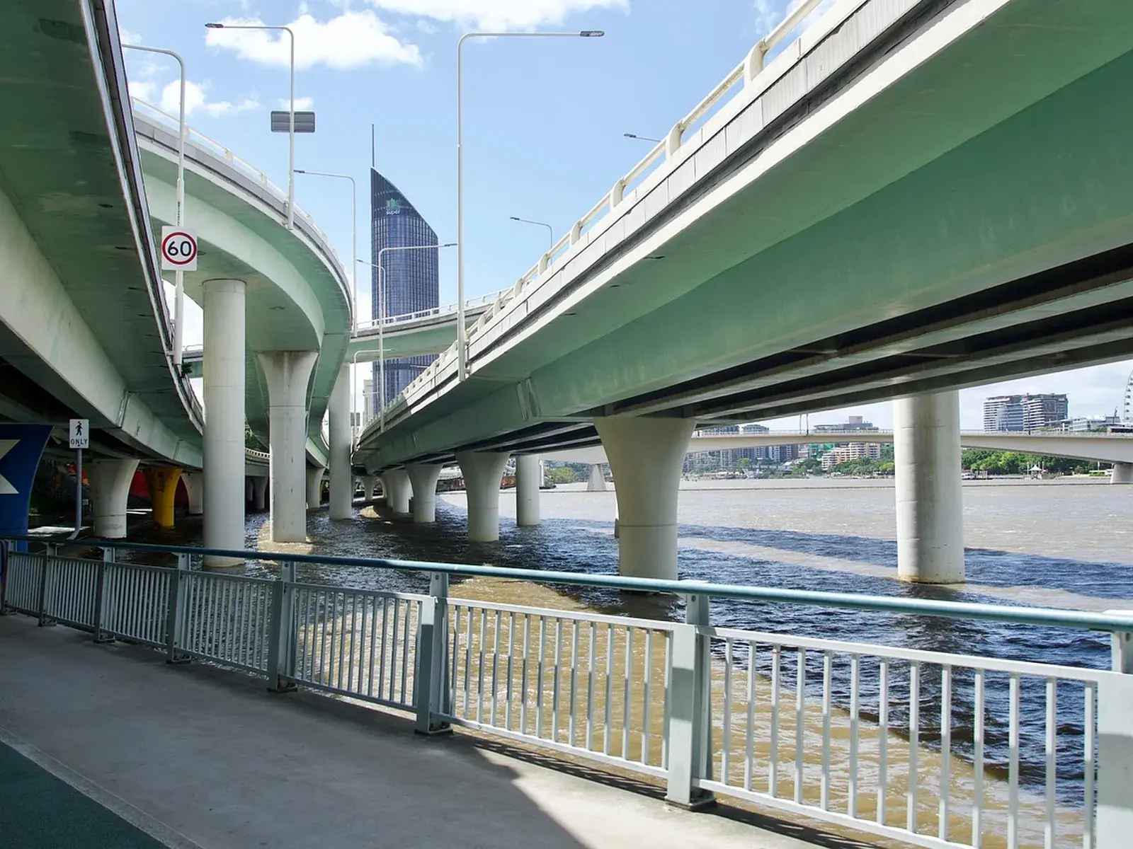 A multi-level flyover interchange carried on concrete piers across a river